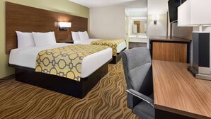 A hotel room with two beds, a desk, a chair, and a TV. - Baymont by Wyndham Griffin (Griffin)
