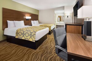 Two single beds with matching headboards and a large desk with a flat-screen TV.