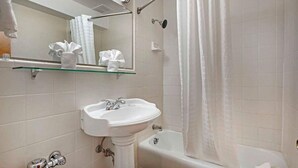 A bathroom with a pedestal sink, a bathtub, a shower curtain, and a mirror with a towel rack.