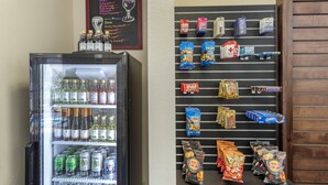 A beverage cooler with various drinks and a snack wall with assorted snacks and beverages.