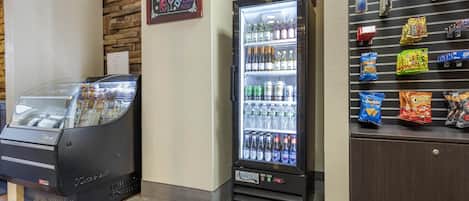 Una máquina expendedora con puerta de cristal, vitrina refrigerada y estante para aperitivos.