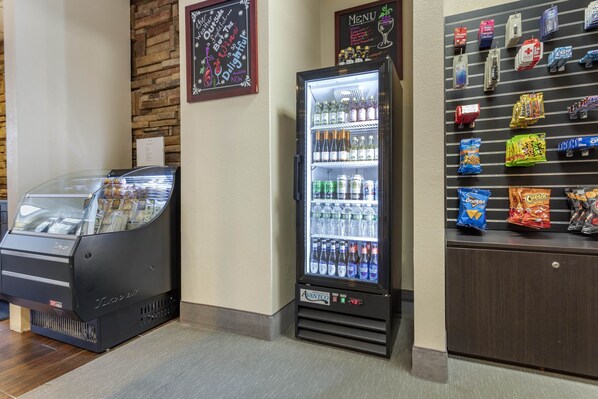 A vending machine with a glass front, a refrigerated display case, and a snack shelf.