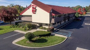 A Red Roof Inn with a parking lot and a landscaped area in front.