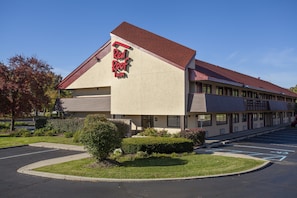 A Red Roof Inn with a modern design, featuring a parking lot and well-maintained landscaping. - Red Roof Inn Detroit - Troy (Troy)