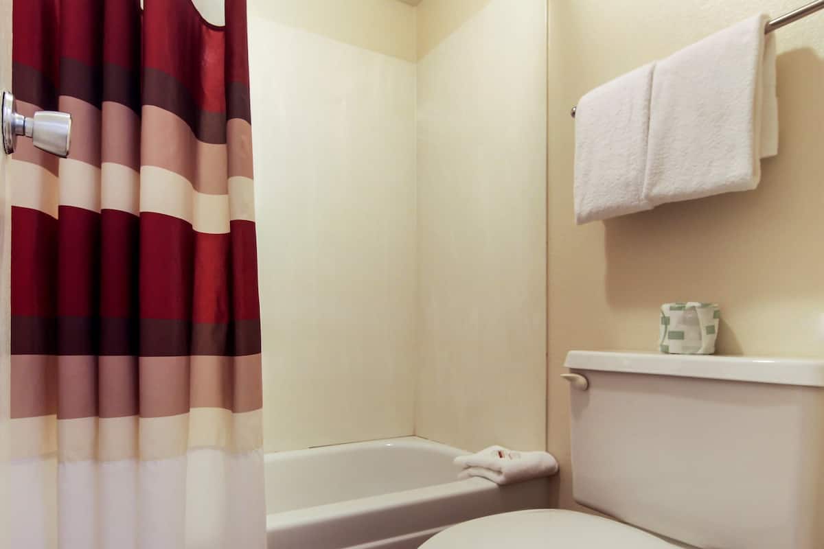 Ein Badezimmer mit einer Badewanne, Toilette und einem Handtuchhalter.