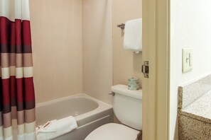 Un bagno con vasca, servizi igienici e tenda da doccia.