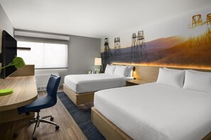 A hotel room with a bed, a desk, a chair, a lamp, and a large wall mural. - Best Western Plus Butte Plaza Inn (Butte)