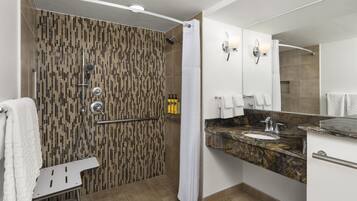 A modern bathroom with a shower, a vanity with a sink, and a mirror.