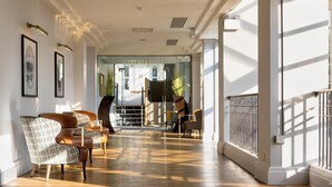 A spacious lobby with patterned chairs, a piano, and a glass entrance to a hallway. - DoubleTree by Hilton Stoke on Trent (Stoke-on-Trent)