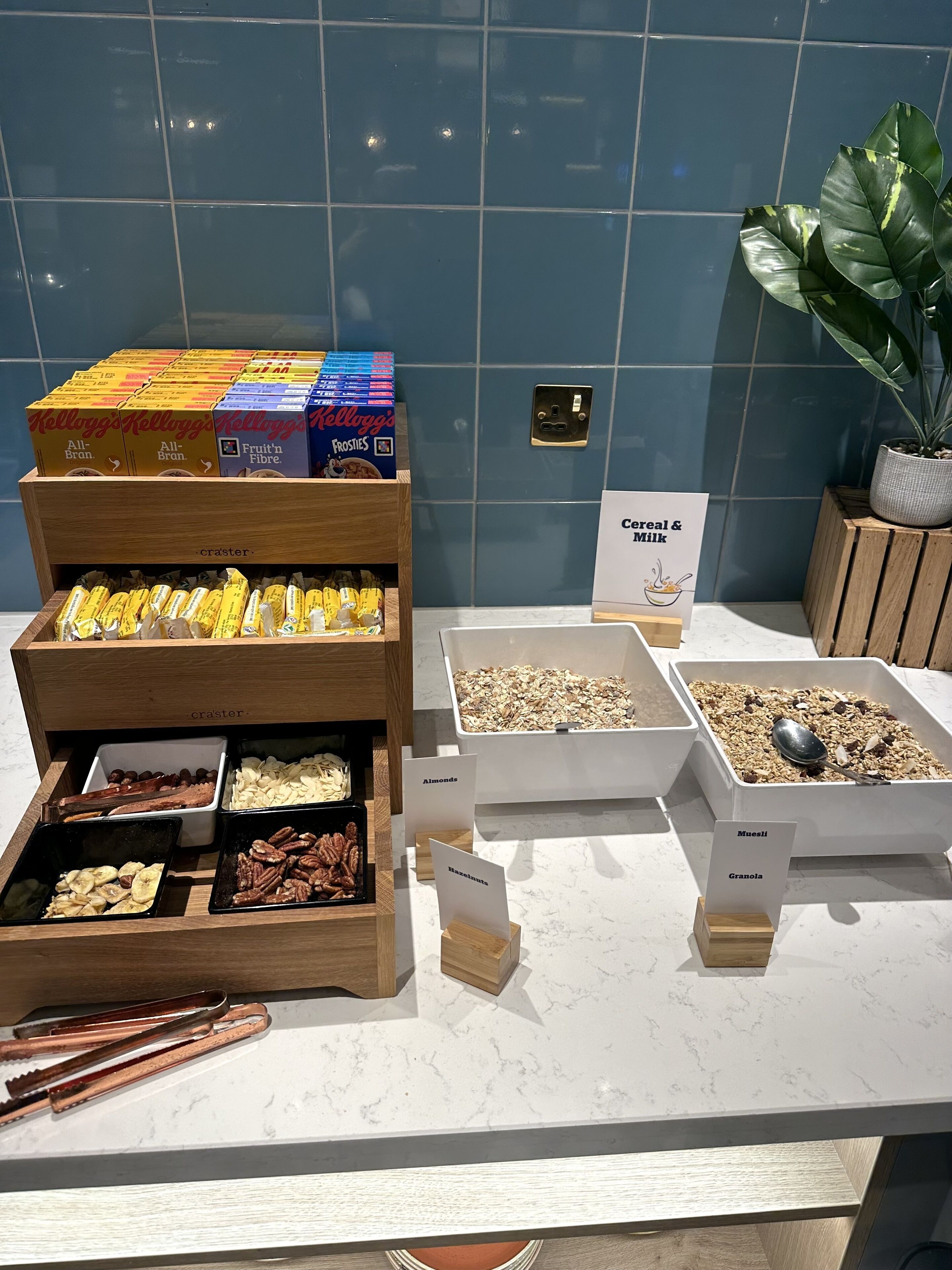 A breakfast buffet with various cereals, fruits, and nuts.