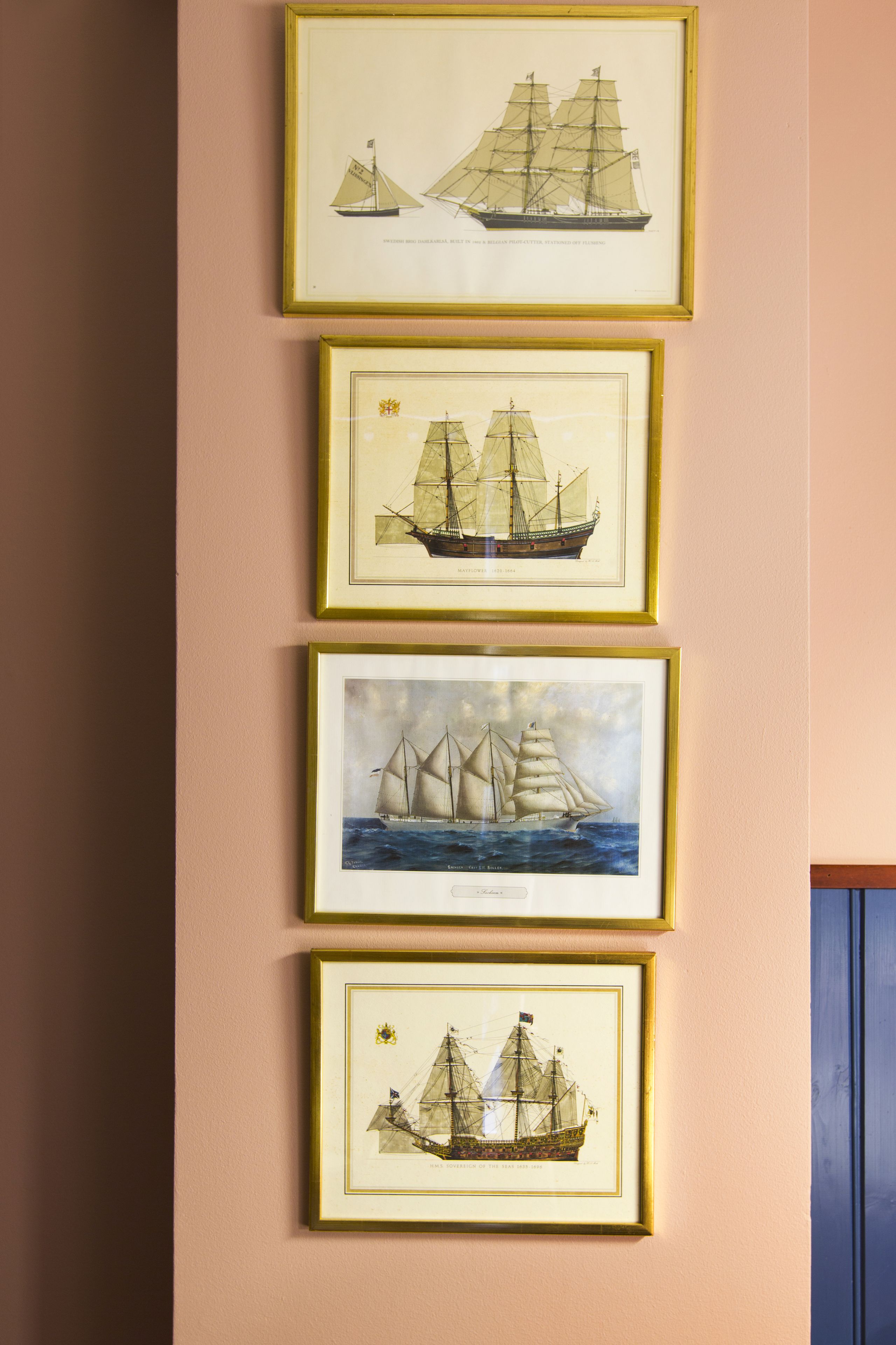 Four framed maritime paintings on a wall.