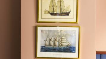 Four framed maritime paintings on a wall.