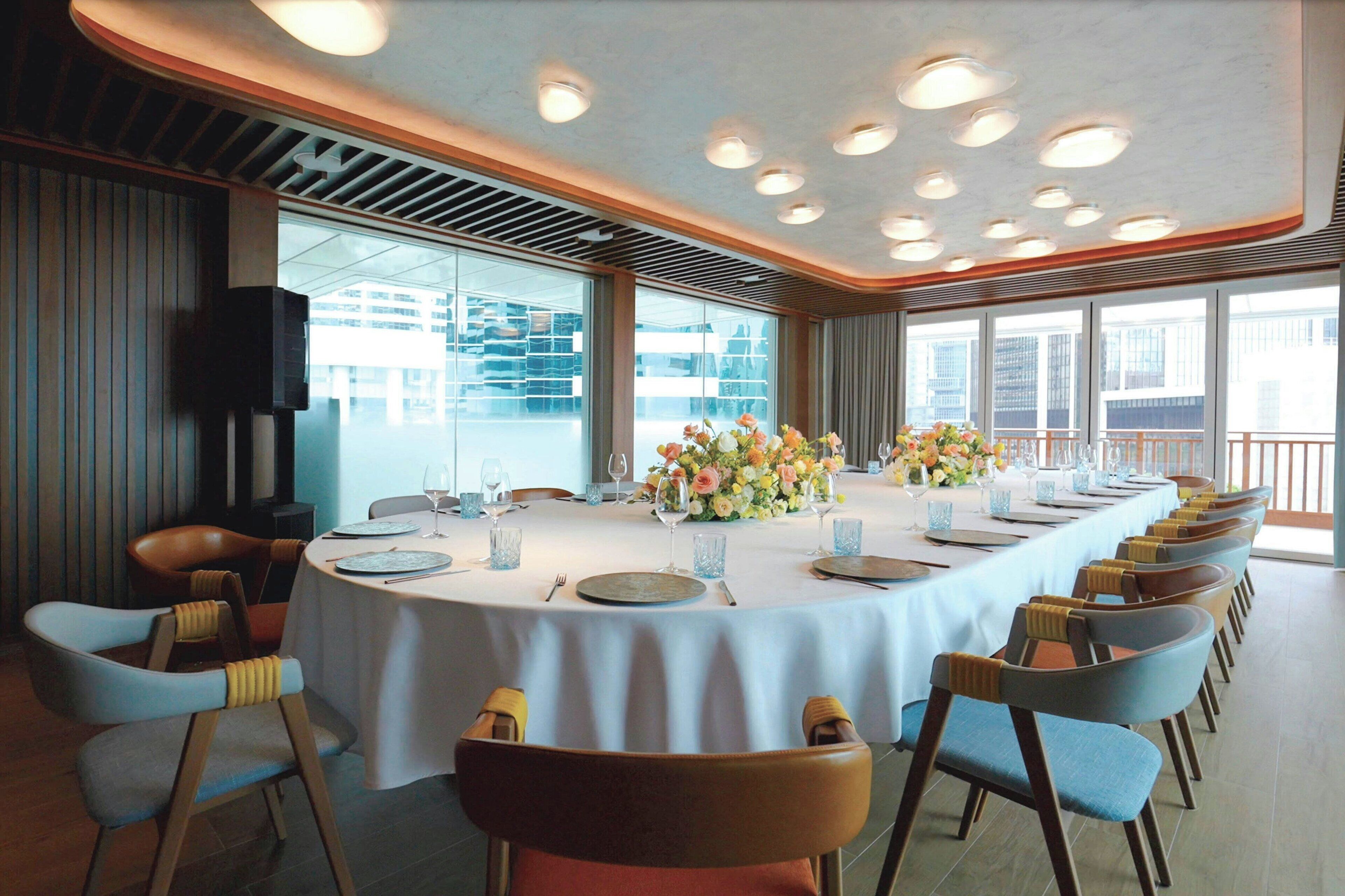 A conference room with a long table, chairs, and a speaker.
