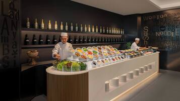 Disposição de buffet com diversos alimentos e uma seleção de garrafas de vinho.