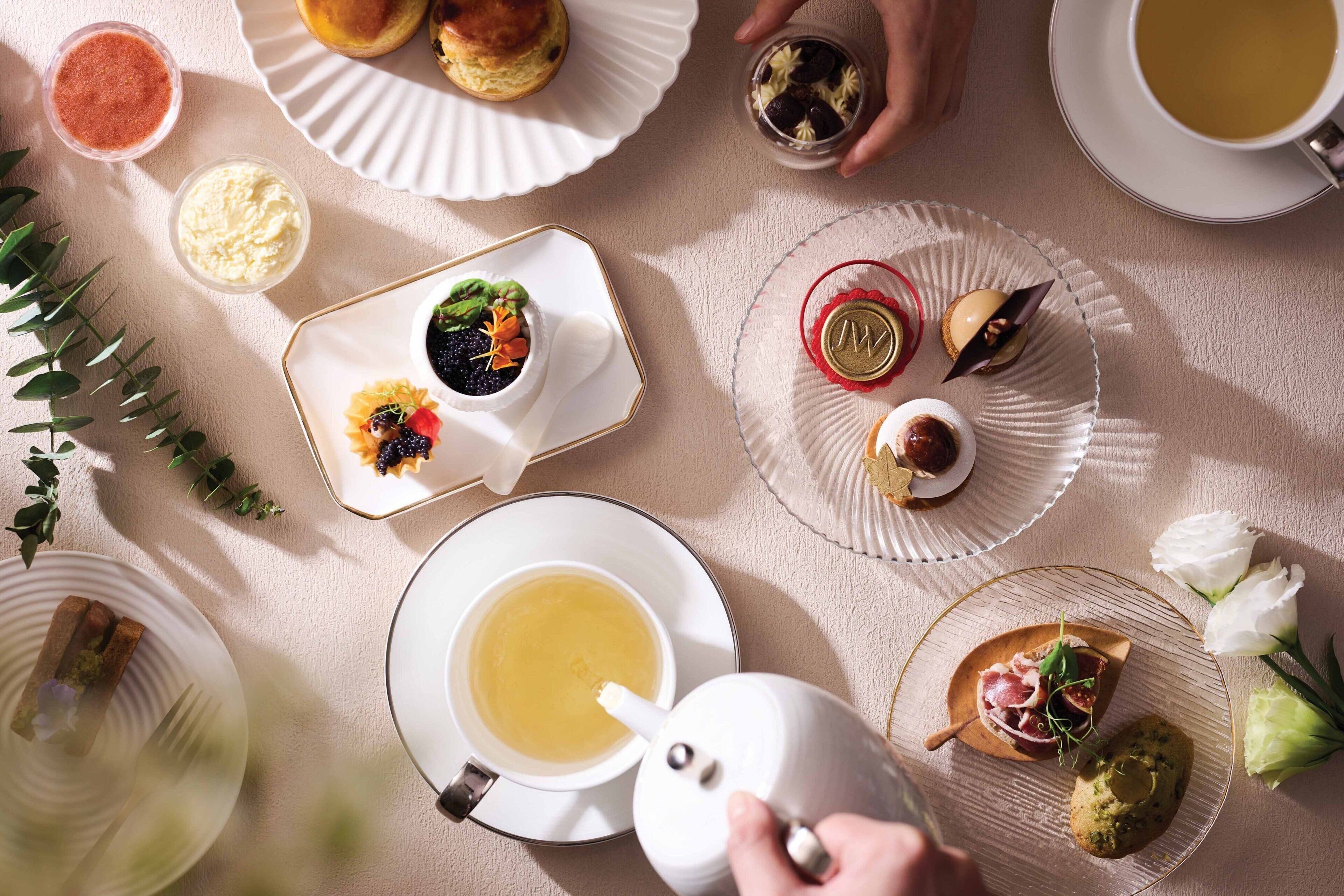A table set with various food items and a teapot, suggesting a dining experience.