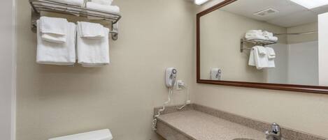 A bathroom with a toilet, sink, towel rack, and a mirror.