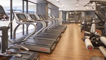 A gym with treadmills, elliptical machines, and weight equipment.