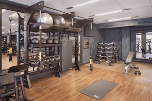 A gym with various exercise equipment, including weights, a treadmill, and a stationary bike.