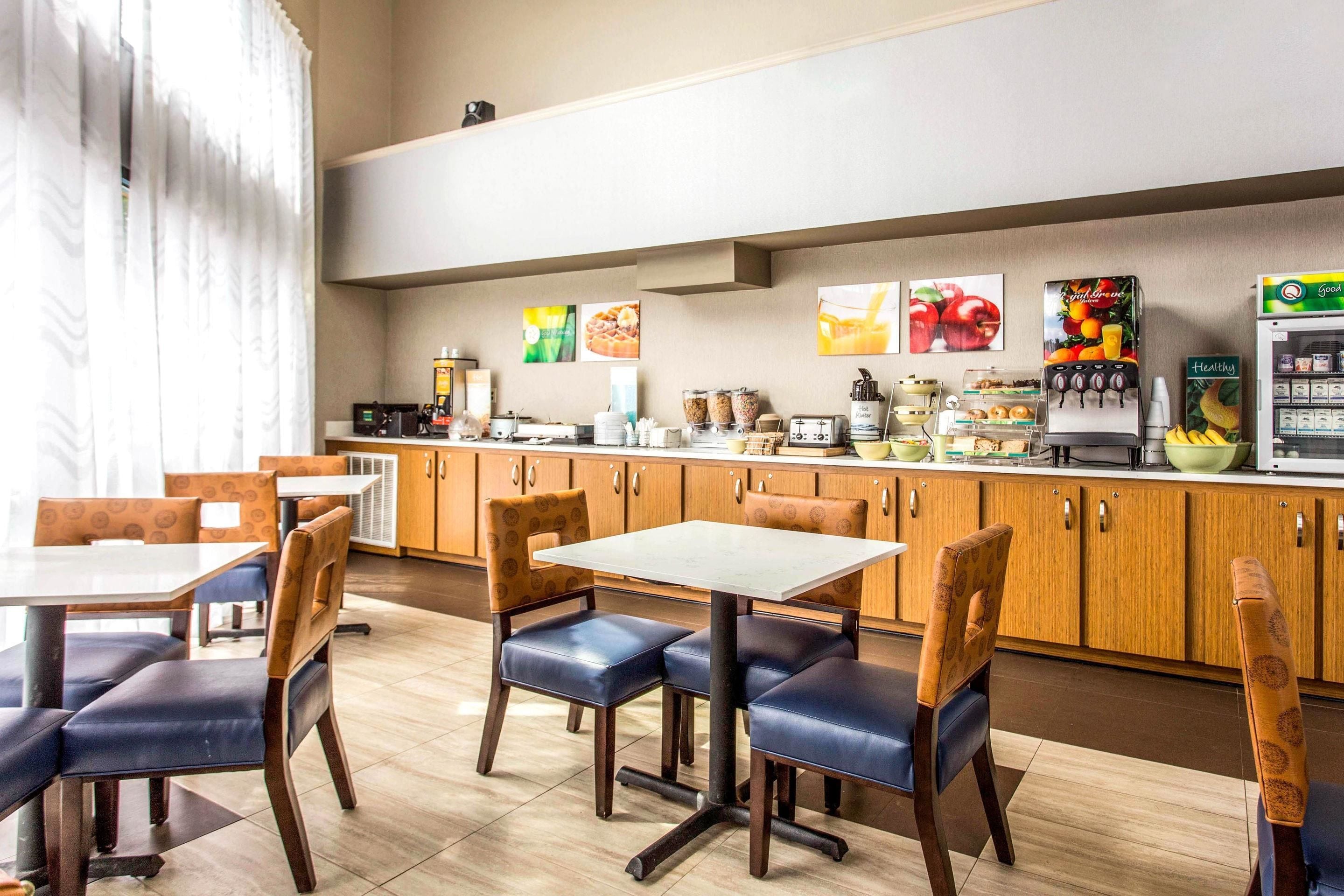 A restaurant with wooden cabinets, a coffee machine, and a refrigerator.