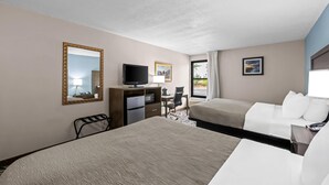Una camera d'albergo con un letto, una scrivania, una sedia, una televisione e una finestra con tende.