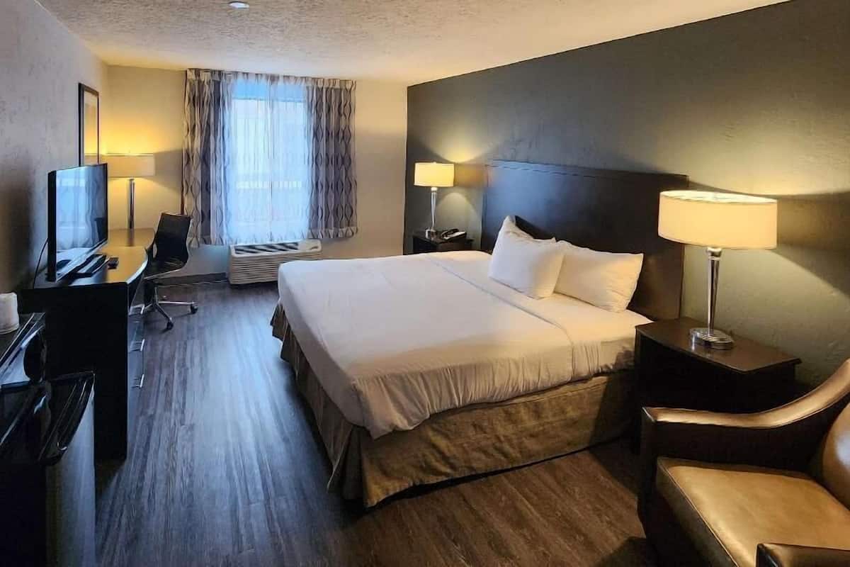 Une chambre d’hôtel équipée d’un lit, d’un bureau, d’une chaise et d’un téléviseur.