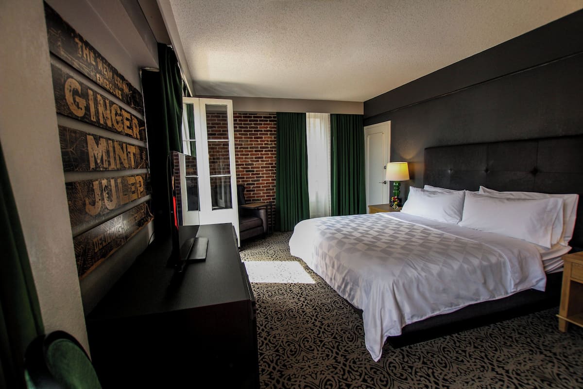 Ein Hotelzimmer mit einem großen Bett, einem Schreibtisch und einer Wand mit Beschriftung.
