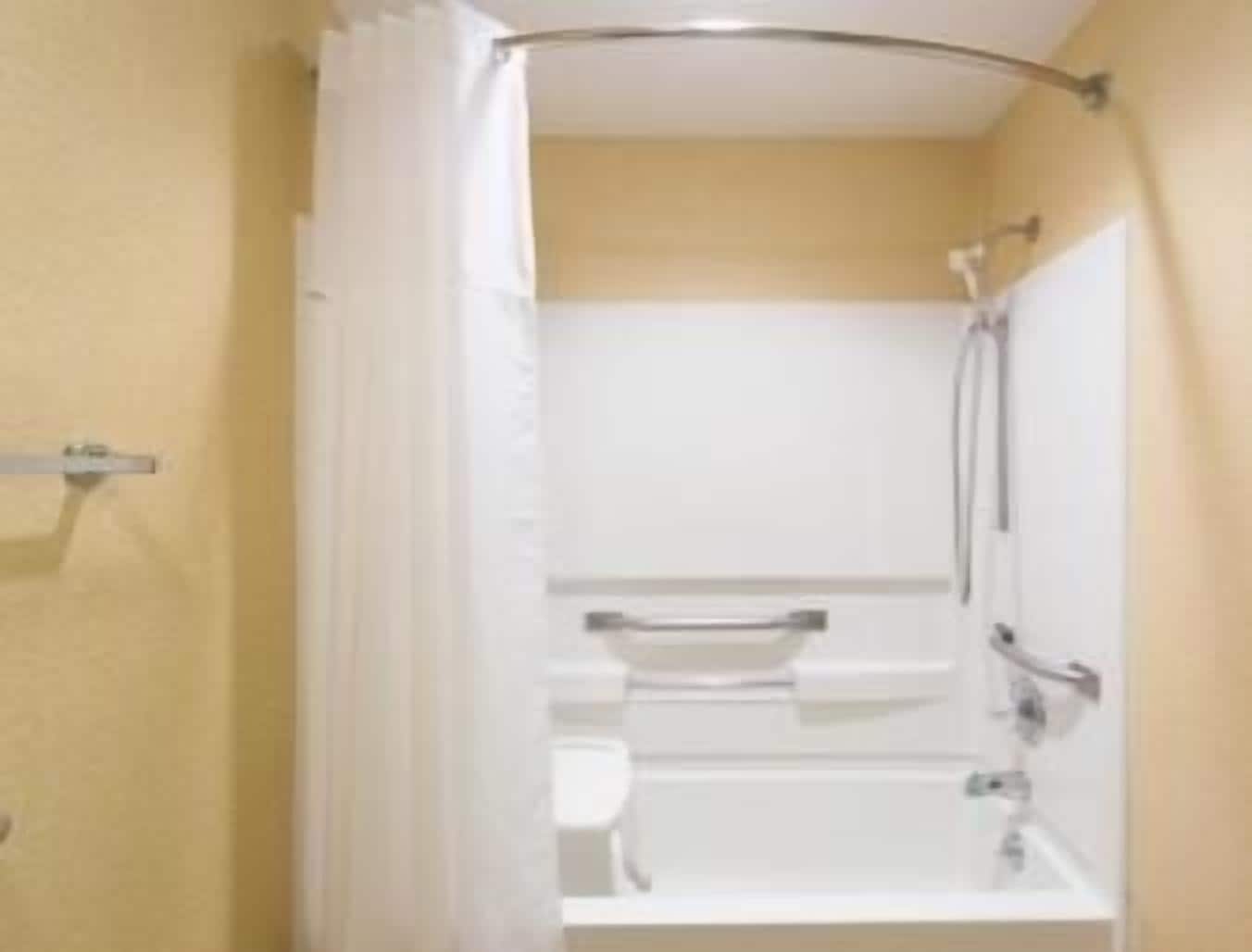 A bathroom with a bathtub, a toilet, and a shower area.