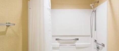 A bathroom with a bathtub, a toilet, and a shower area.