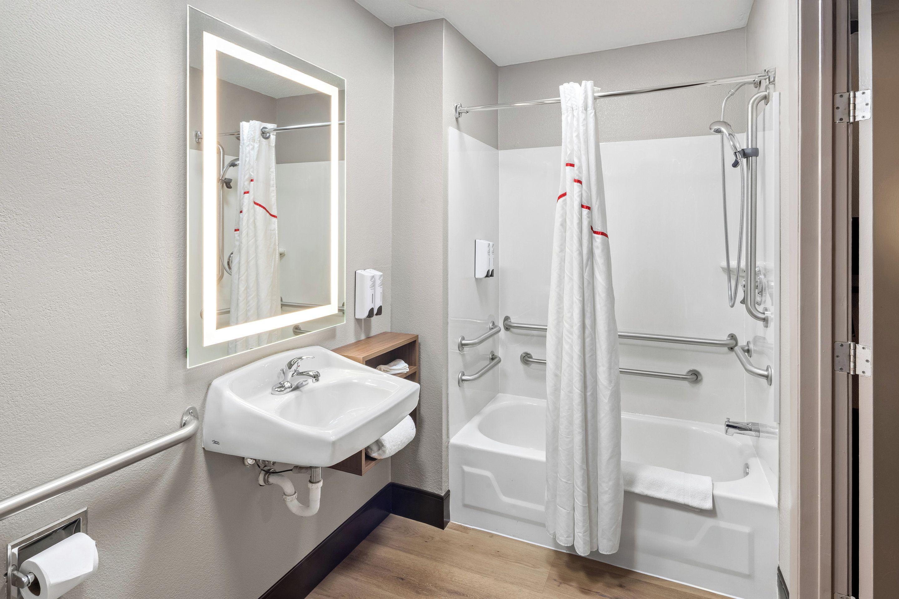 A modern bathroom with a sink, mirror, and walk-in shower.