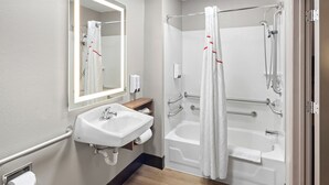 A modern bathroom with a sink, mirror, and walk-in shower. - Red Roof Inn PLUS+ Columbus-Ohio State University OSU (Columbus)