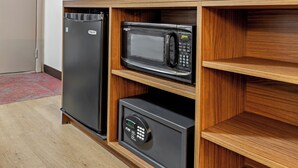 A compact kitchen with a built-in refrigerator, microwave, and oven.