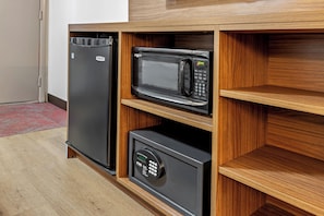 A compact kitchen with a built-in refrigerator, microwave, and oven.