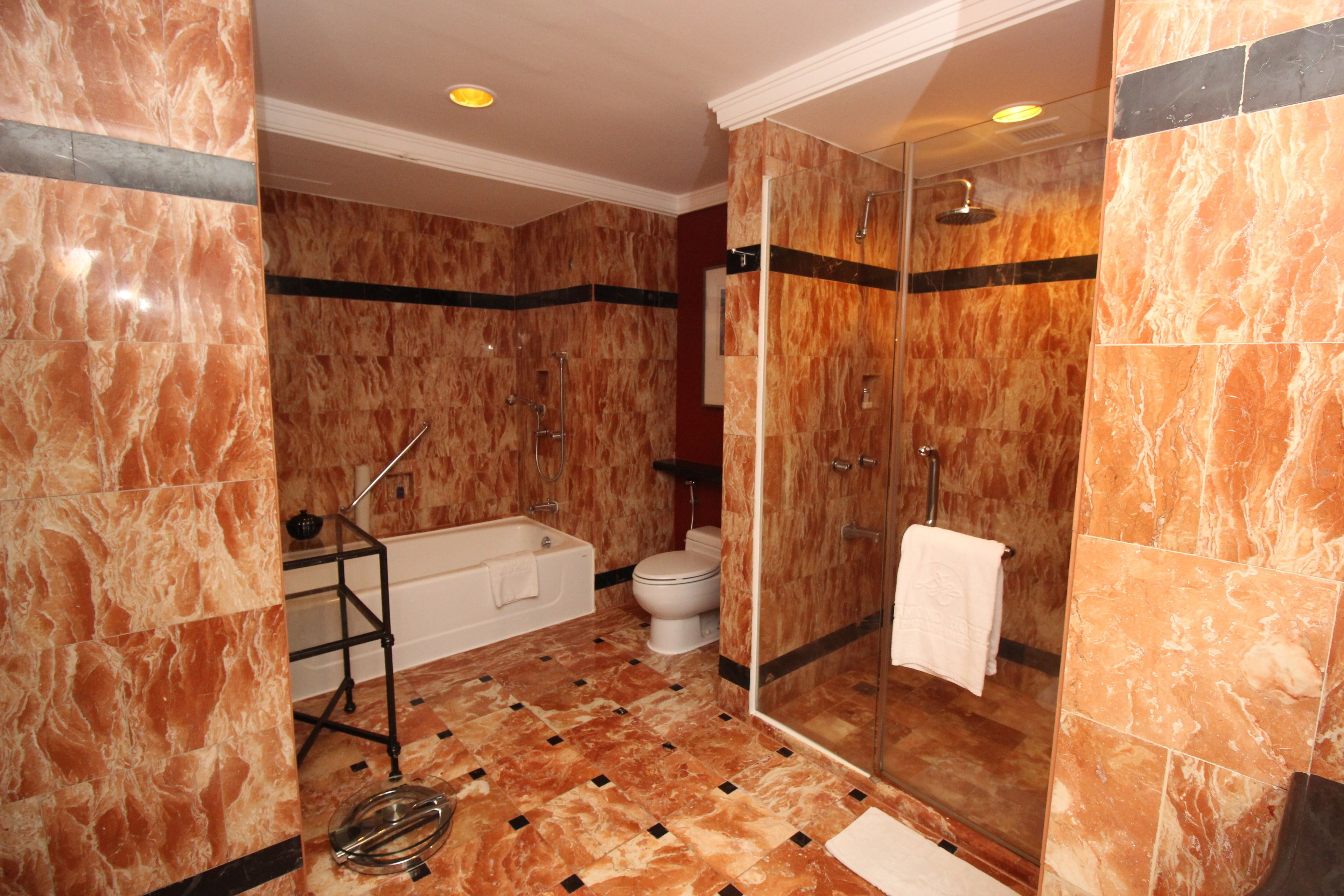 A bathroom with a bathtub, toilet, and glass-enclosed shower area.