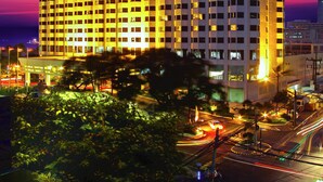 A high-rise hotel with multiple floors, illuminated windows, and a prominent sign at the top. - Diamond Hotel Philippines (Manila)