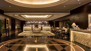 A spacious lobby with a central reception desk, seating area, and a patterned floor. - Diamond Hotel Philippines (Manila)