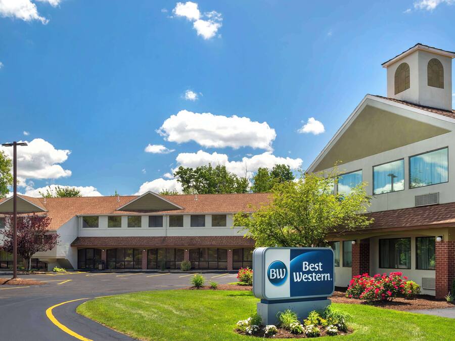 A Best Western hotel with a large sign, a parking lot, and a clear blue sky.