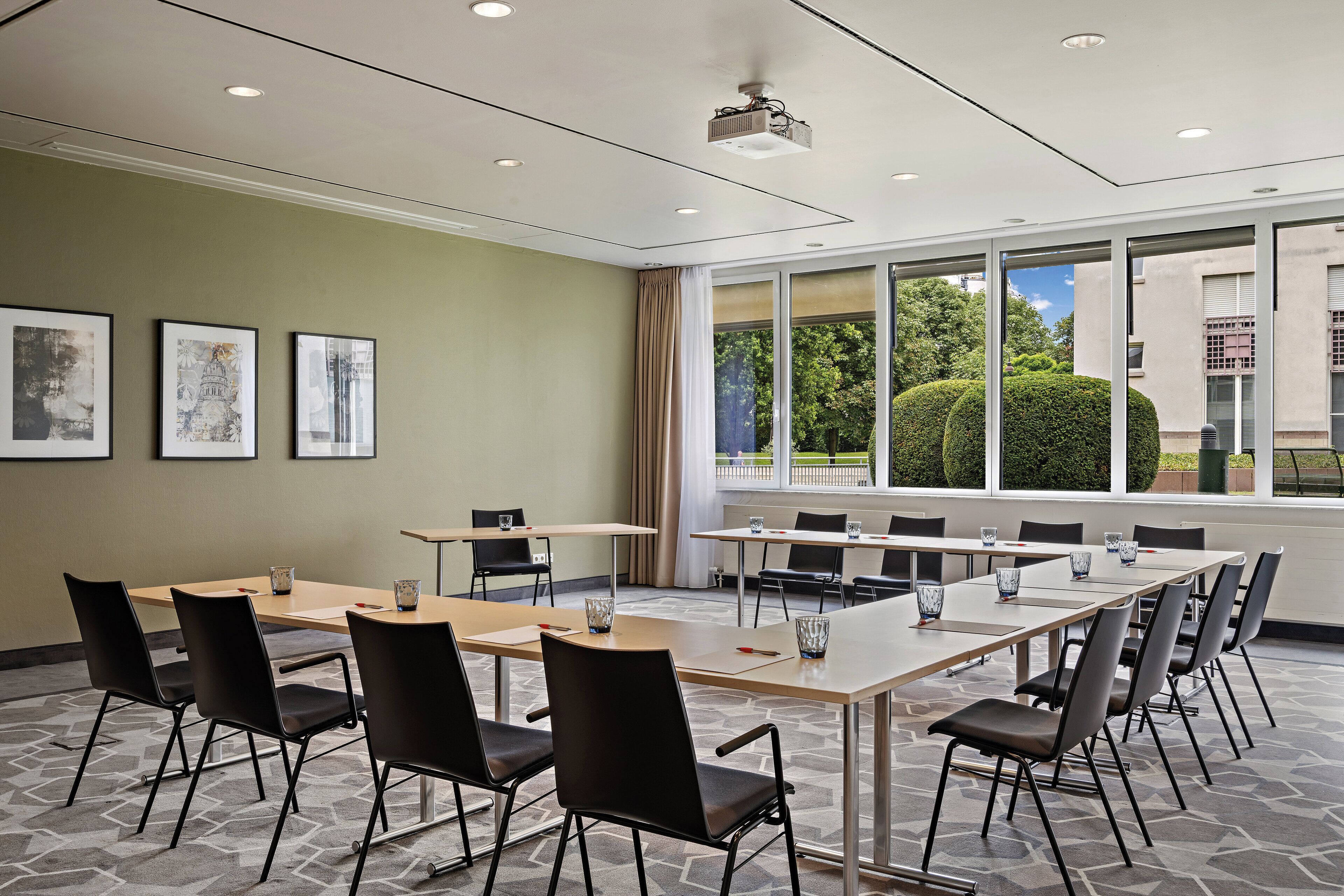 Une salle de conférence équipée d’une grande table, de chaises et d’un projecteur.
