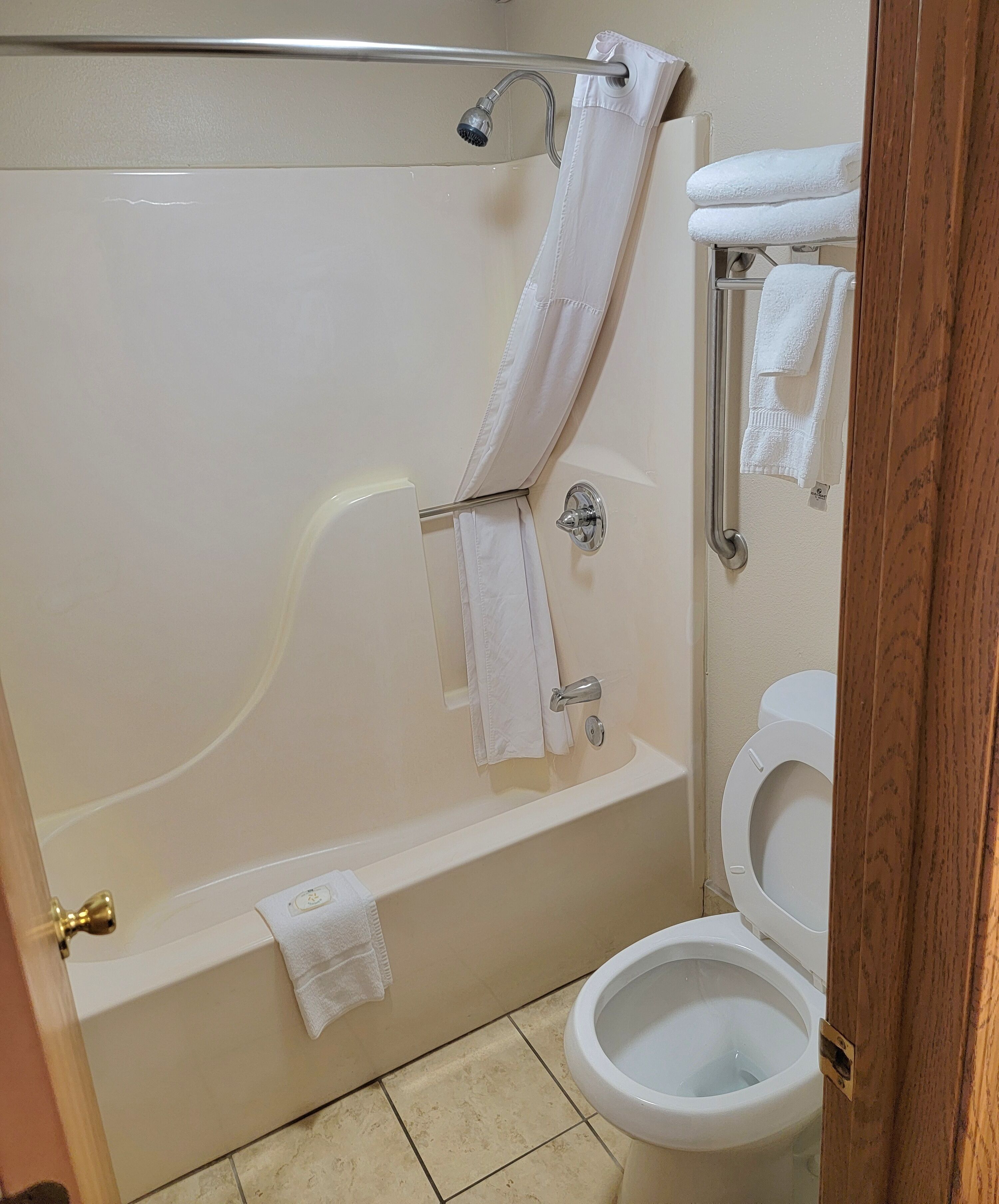 Een badkamer met een bad, toilet en douche.