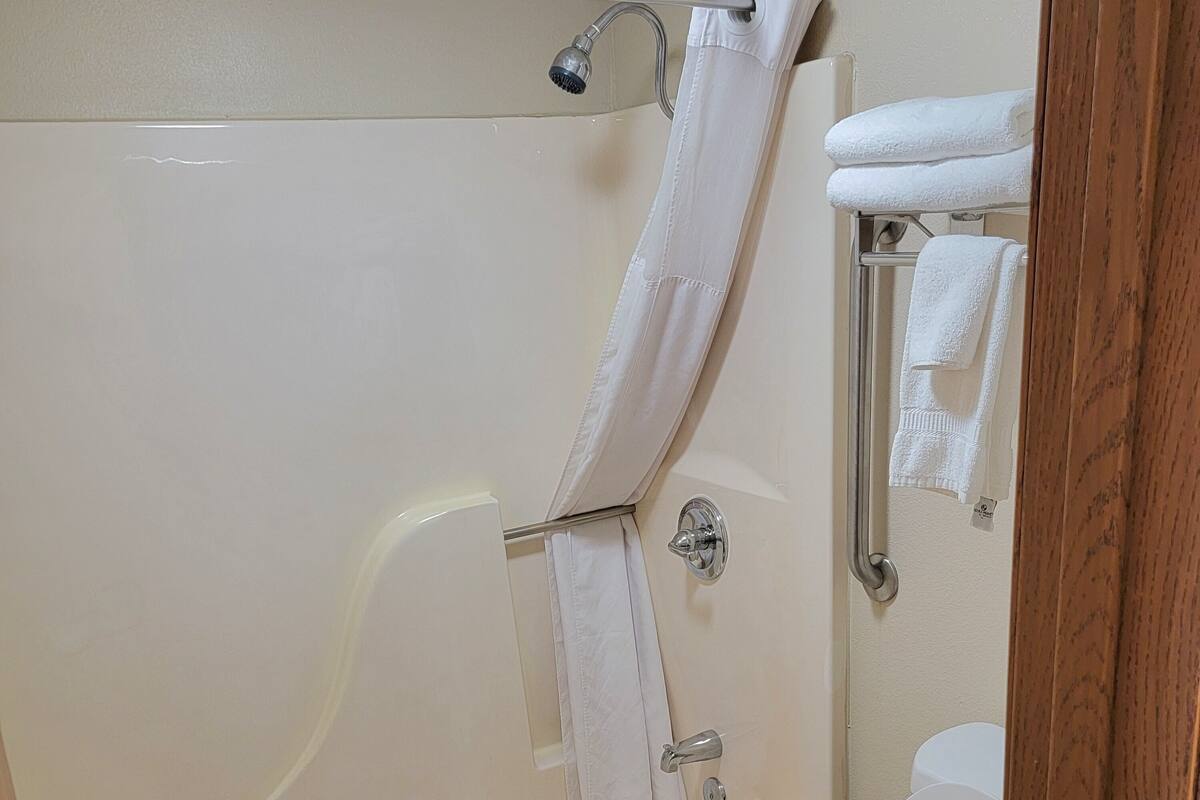 A bathroom with a bathtub, toilet, and shower.