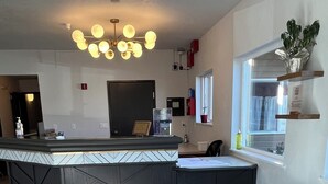 A modern kitchen with a central island, a blue sofa, and a gold-leaf table. - Americas Best Value Inn & Suites Forest Grove Hillsboro (Forest Grove)