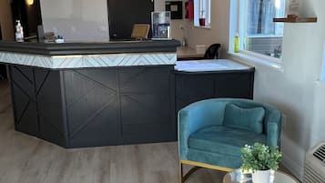Relax in this stylish space with a central island counter, teal sofa, and a small table with a gold leaf design.