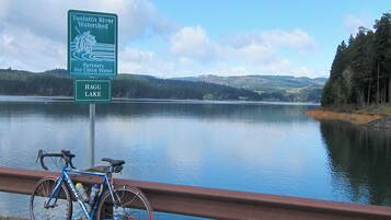 Skilt for Tualatin River Watershed og Hag Lake, med en cykel parkeret ved et gelænder med udsigt over søen.