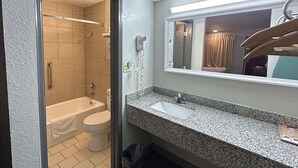A bathroom with a bathtub, toilet, and sink. - Motel 6 Ada, OK (Ada)