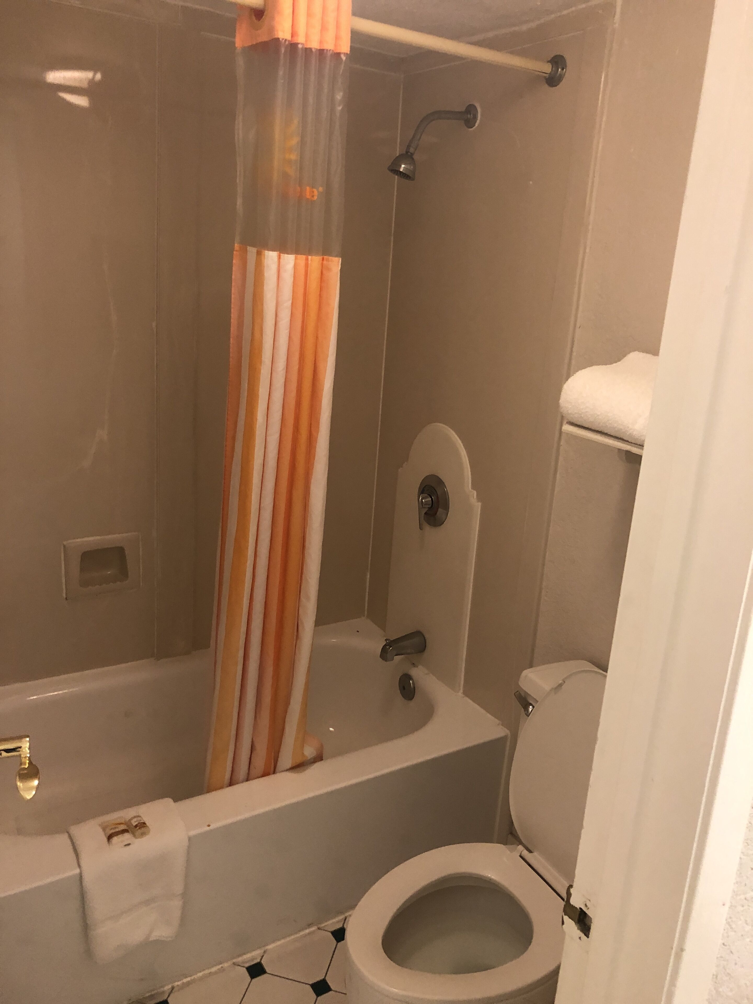 Un baño con bañera, inodoro y cortina de ducha.