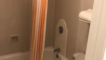 Un baño con bañera, inodoro y cortina de ducha.