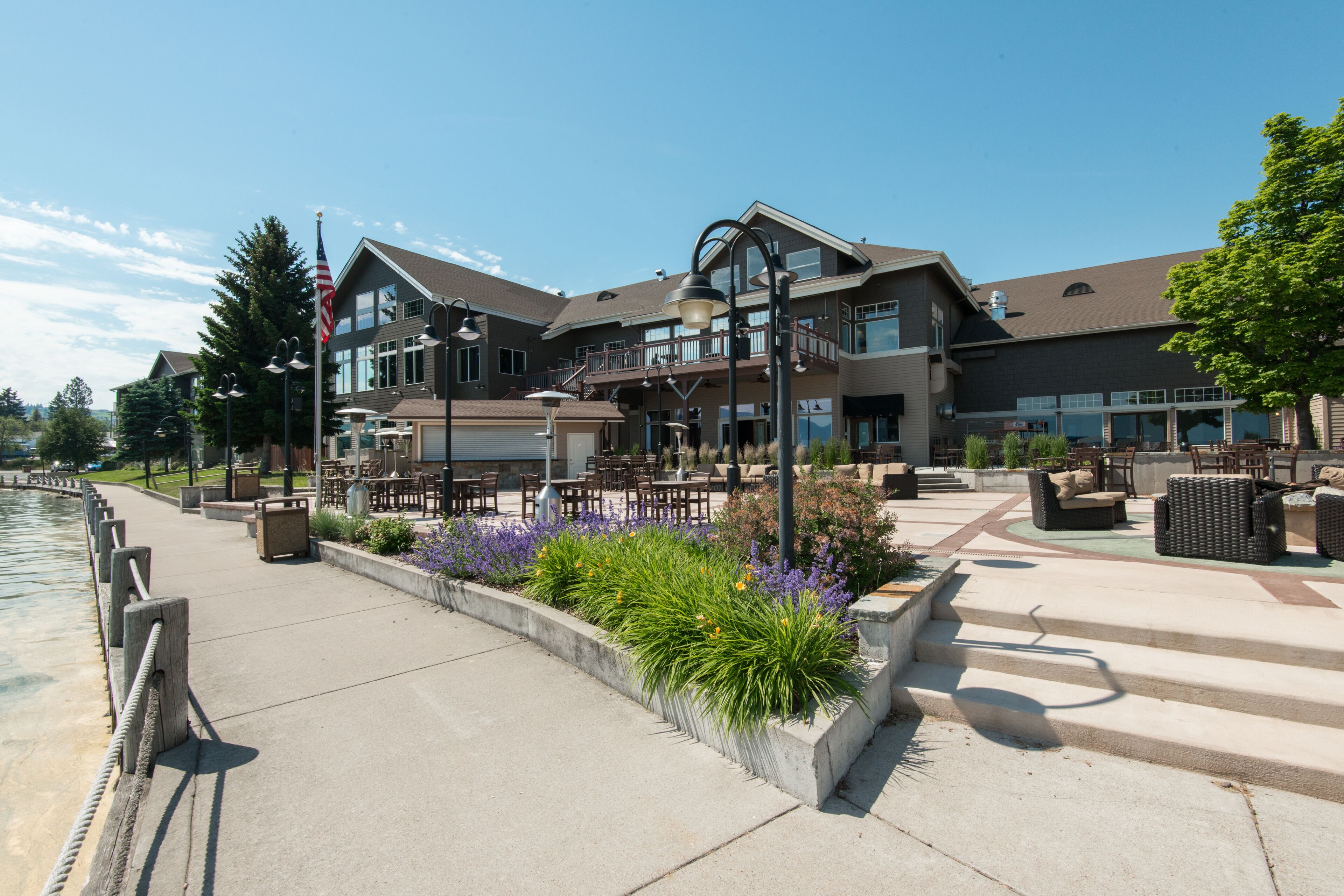 A hotel with a patio area featuring outdoor seating and a view of the water.