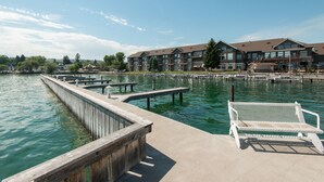 A waterfront hotel with a dock, benches, and a view of the water. - KwaTaqNuk Resort & Casino (Polson)