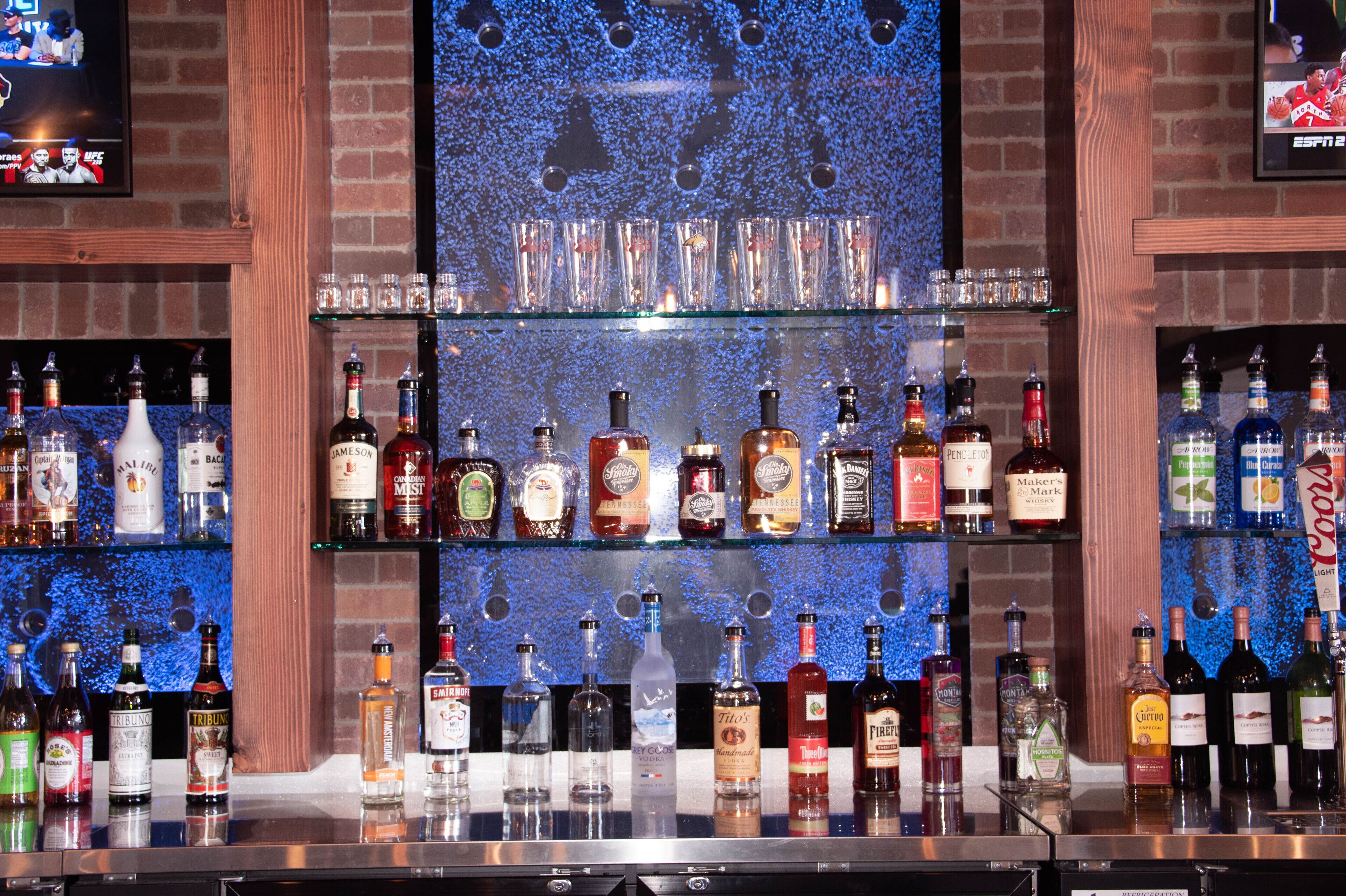A bar with multiple shelves of liquor bottles.