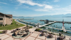 A waterfront hotel with outdoor seating, a dock, and a view of the water and mountains. - KwaTaqNuk Resort & Casino (Polson)