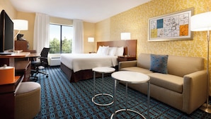 A hotel room with a bed, a sofa, a desk with a chair, a TV, and a lamp. - Fairfield Inn by Marriott Philadelphia Valley Forge (King of Prussia)
